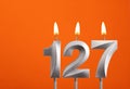 Candle number 127 - Birthday in orange background