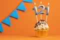 Birthday cupcake with candle number 121 - Orange background