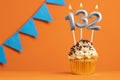Candle number 132 - Cupcake birthday in orange background Royalty Free Stock Photo