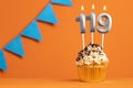 Birthday cupcake with candle number 119 - Orange background Royalty Free Stock Photo