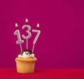 Candle number 137 - cupcake birthday in rhodamine red background Royalty Free Stock Photo