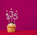 Candle number 135 - cupcake birthday in rhodamine red background Royalty Free Stock Photo