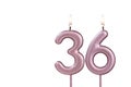 Candle number 36 - Lit birthday candle on white background