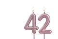 Candle number 42 - Lit birthday candle on white background