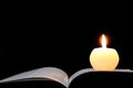 Candle and opened book isolated on black Royalty Free Stock Photo