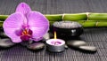 candle with orchids and lava stones
