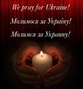 A candle in the palms of a Ukrainian woman who prays for peace in Ukraine.