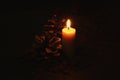 Candle and Pine Cones: Dark scene with flaming candle