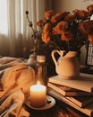 a candle on a plate next to books and flowers Royalty Free Stock Photo