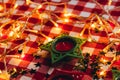 Candle on red checkered tablecloths and garland