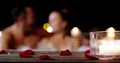 Candle, rose petals and hot tub couple romance, relax and bonding in Valetines Day date conversation. Love, partner