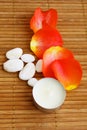 Candle, roses petals and stones on bamboo mat