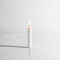 The candle\'s flame is small and steady, casting a faint shadow to the left Royalty Free Stock Photo