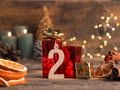 Candle of the second Advent burns, pine cones and Christmas decoration on wood Royalty Free Stock Photo