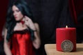 Candle and Silver Dollar With Woman wearing vintage corset in background Royalty Free Stock Photo