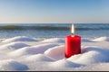 Candle in the snow. on the sea beach.
