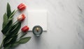 a candle and some tulips on a marble surface