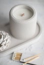 Candle, white color, in a unique candle holder concrete and oval coaster made from concrete in white colors. Matches for Royalty Free Stock Photo