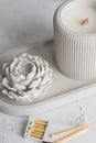 Candle, white color, in a unique candle holder concrete and oval coaster made from concrete in white colors. Matches for Royalty Free Stock Photo