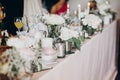 Candle, White  flowers in modern glass vase on pink centerpiece. Stylish luxury decor on wedding table.Luxury catering and Royalty Free Stock Photo