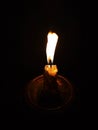 Burning candle in a candlestick on a black background Royalty Free Stock Photo