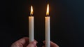 Candlelit Serenity: Hands Embrace Illumination in Enigmatic Darkness