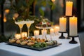 candlelit table with appetizers and drinks at an evening event