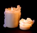 Two lit drippy candles on a black background. Royalty Free Stock Photo