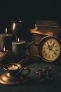 Candles, antique books, old clock and old rusty keys in vintage style