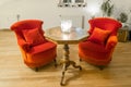 Candles on a antique side table with intarsia and red chair