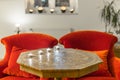 Candles on a antique side table with intarsia and red chair