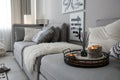 Candles and aroma reed diffuser on grey sofa, space for text