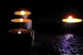 Candles burning on a black background. The concept of grief, mourning.
