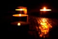 Candles burning on a black background. The concept of grief, mourning. You can use it as a banner.