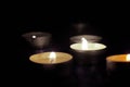 Candles burning in the dark with a soft selective focus. The concept of mourn, grief or mourning.