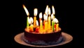 Candles burning out on delicious chocolate cake, isolated on black background Royalty Free Stock Photo