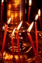 Candles in the church, close-up. Burning candle near the yellow altar in the church. Golden light of a warm fire on a dark Royalty Free Stock Photo