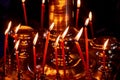 Candles in the Church, close-up. Yellow light of a warm fire on a dark background. Burning candles near the Golden altar in the Royalty Free Stock Photo