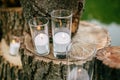 Candles in decorated goblets. Wedding decorations in rustic style. Outing ceremony. Wedding in nature.