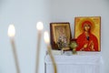 Candles in front of icons in the Orthodox church. A burning wax candles, cross and icons in monastery. Christian religion. Altar i Royalty Free Stock Photo