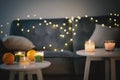 Candles and garlands on a gray sofa in the living room, christmas and new year comfort at home concept