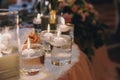 Candles with lights in glasses with water, stylish wedding decor for evening ceremony or at reception in restaurant. Spiritual Royalty Free Stock Photo