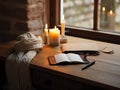 Cozy winter scene with candles and open notebook by the window Royalty Free Stock Photo