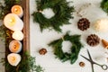 Candles and rustic christmas wreath with pine cones on white wooden table Royalty Free Stock Photo