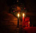 Candles and Santa Claus with Christmas decorations in dark interior Royalty Free Stock Photo