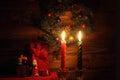 Candles and Santa Claus with Christmas decorations in dark interior Royalty Free Stock Photo