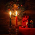 Candles and Santa Claus with Christmas decorations in dark interior Royalty Free Stock Photo