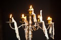 Candles in a shiny brass chandelier.