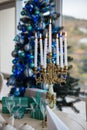 Candlestick with lighted candles at a Christmas tree with gifts Royalty Free Stock Photo