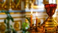 A candlestick with lighted candles in front of icons in an Orthodox church. The concept of Orthodoxy. Royalty Free Stock Photo